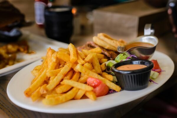 Delicious plate of golden french fries with dipping sauces, perfect for a satisfying meal.